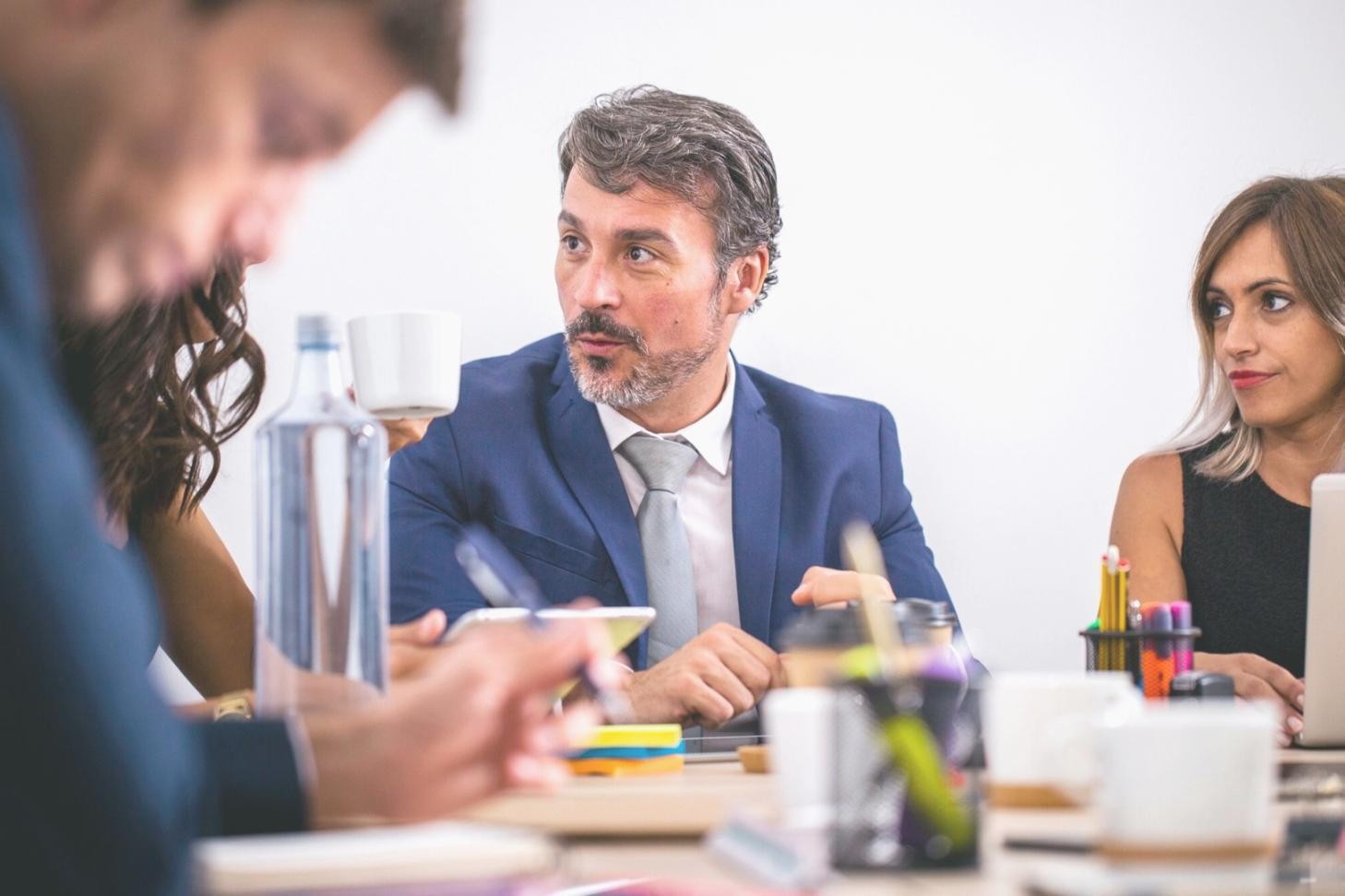 Business professionals analyzing financial charts and implementing budget planning methodologies in collaborative workspace